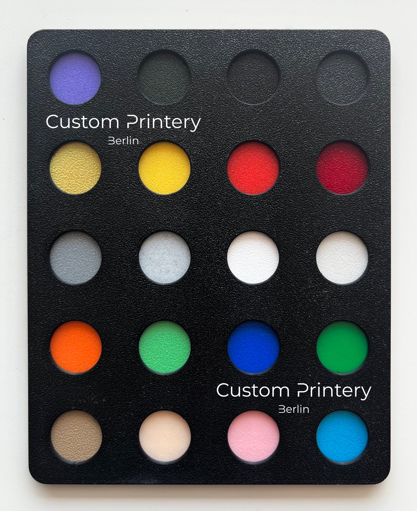 Custom black Crocs with colorful personalized name charms for 'Lena,' 'Noah,' 'Theo,' and 'Clara' from Custom Printery Berlin, showcased in a casual indoor setting with green plants.