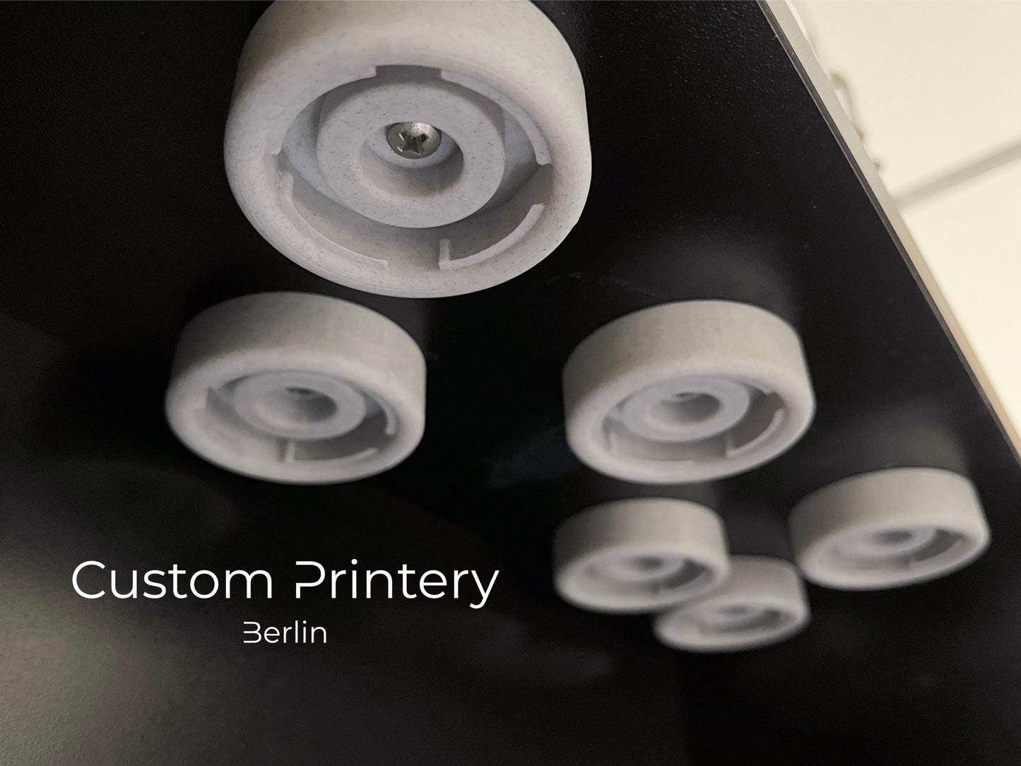 Schwarze Wandhalterung für Dyson Haarstyling-Gerät und Zubehör. Die Halterung enthält den Haartrockner, verschiedene Styling-Aufsätze und ist sauber organisiert. Oben auf dem Regal steht eine moderne Vase mit getrockneten Eukalyptuszweigen.