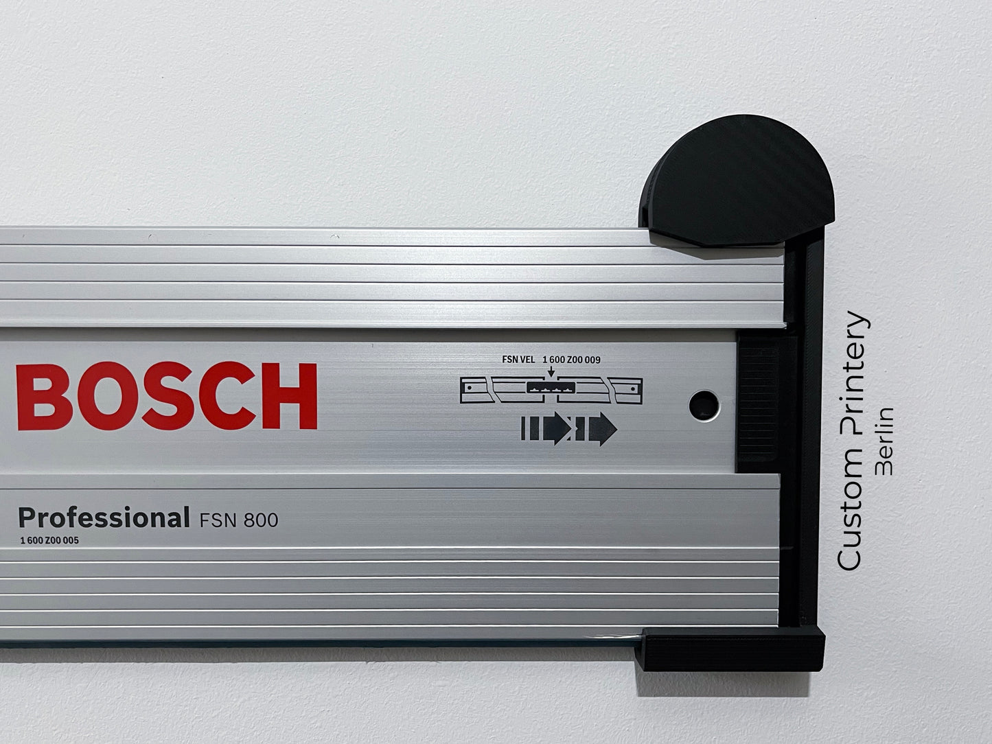 Schwarze Halterung für Bosch FSN Mafell Makita Festool Führungsschienen, montierbar an Wand oder Decke. Ideal zur sicheren, platzsparenden Aufbewahrung in Werkstätten. Arretiermechanismus für stabilen Halt, einfache Befestigung durch Schrauben oder Klebeband