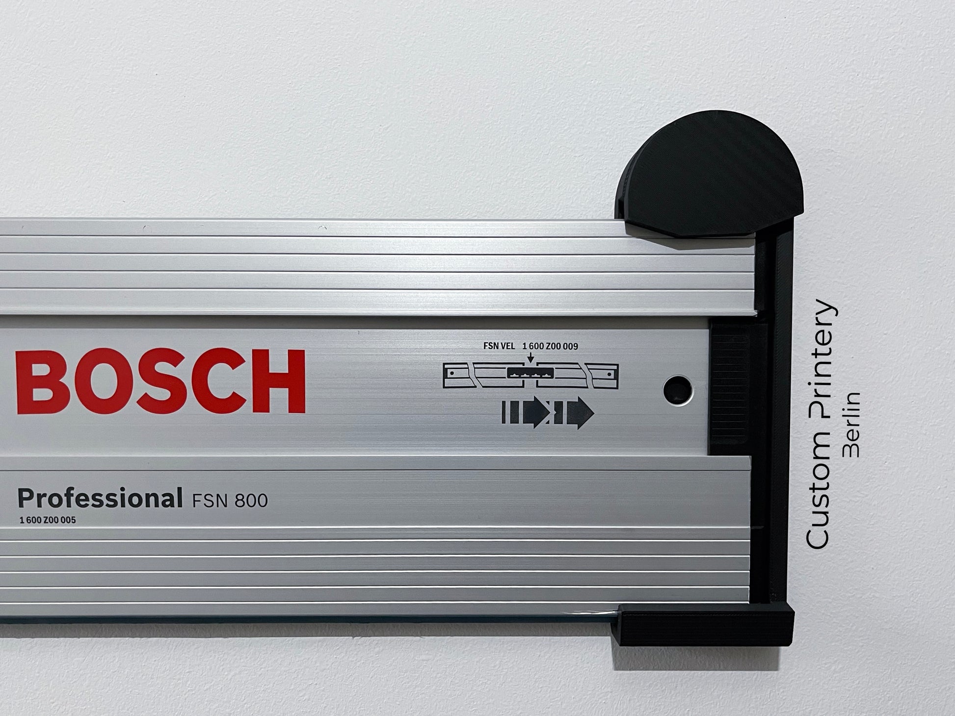 Schwarze Halterung für Bosch FSN Mafell Makita Festool Führungsschienen, montierbar an Wand oder Decke. Ideal zur sicheren, platzsparenden Aufbewahrung in Werkstätten. Arretiermechanismus für stabilen Halt, einfache Befestigung durch Schrauben oder Klebeband