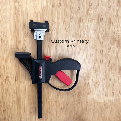 Schwarze 3D-gedruckte Wandhalterung für Bosch FSN KZW Professional Klemmzwinge, montiert an einer Holzwand